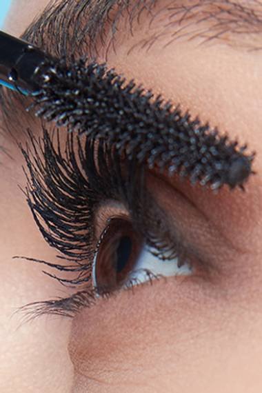 Close up of a woman applying mascara on her Eyelashes